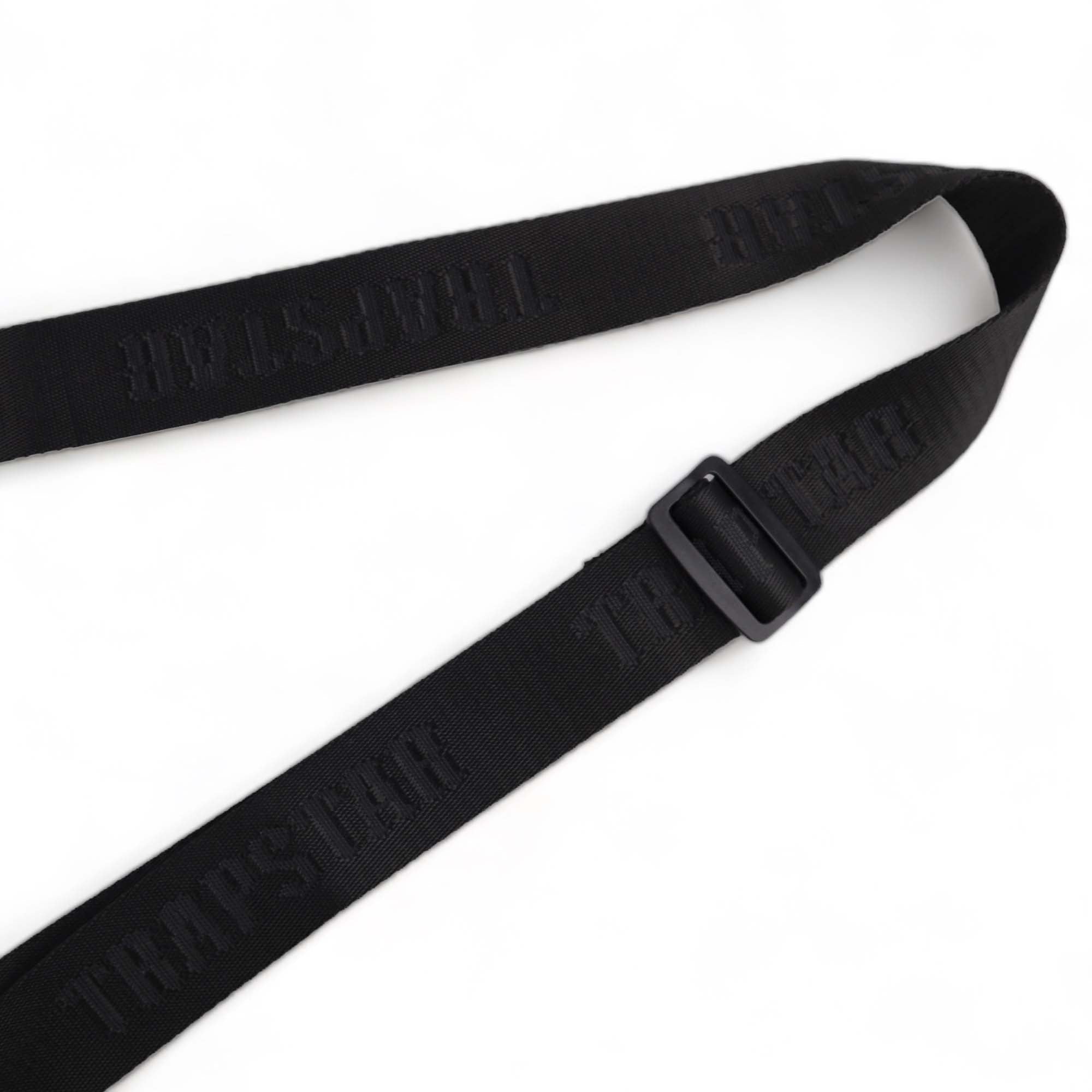 Trapstar black and white Irongate T cross-body bag with adjustable strap and sleek design displayed on a flat surface.