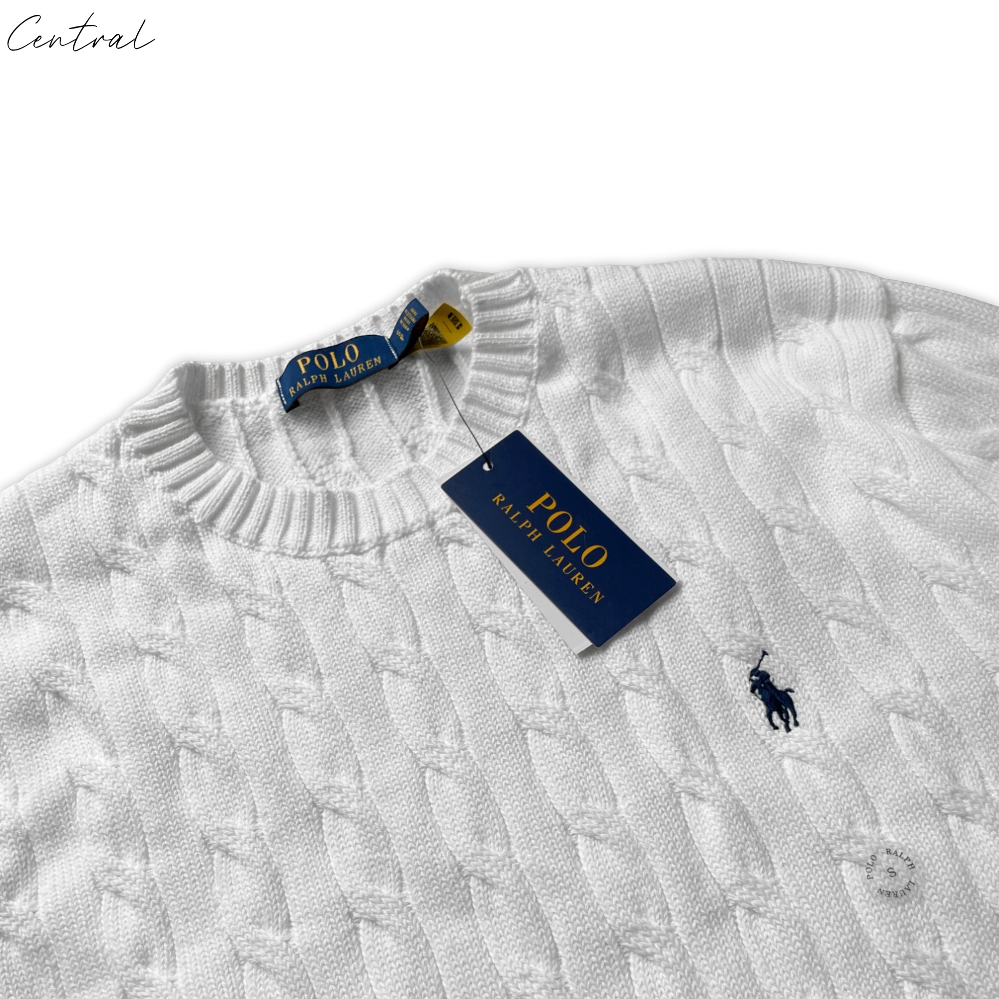 Polo Ralph Lauren white cable-knit cotton jumper displayed on a mannequin with intricate knit pattern and ribbed cuffs.