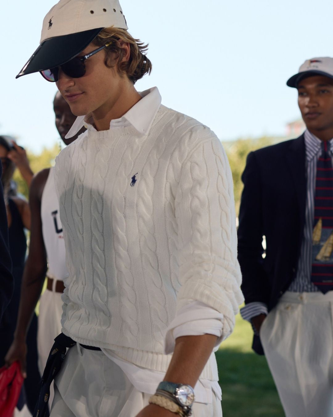 Polo Ralph Lauren white cable-knit cotton jumper displayed on a wooden surface with natural lighting.