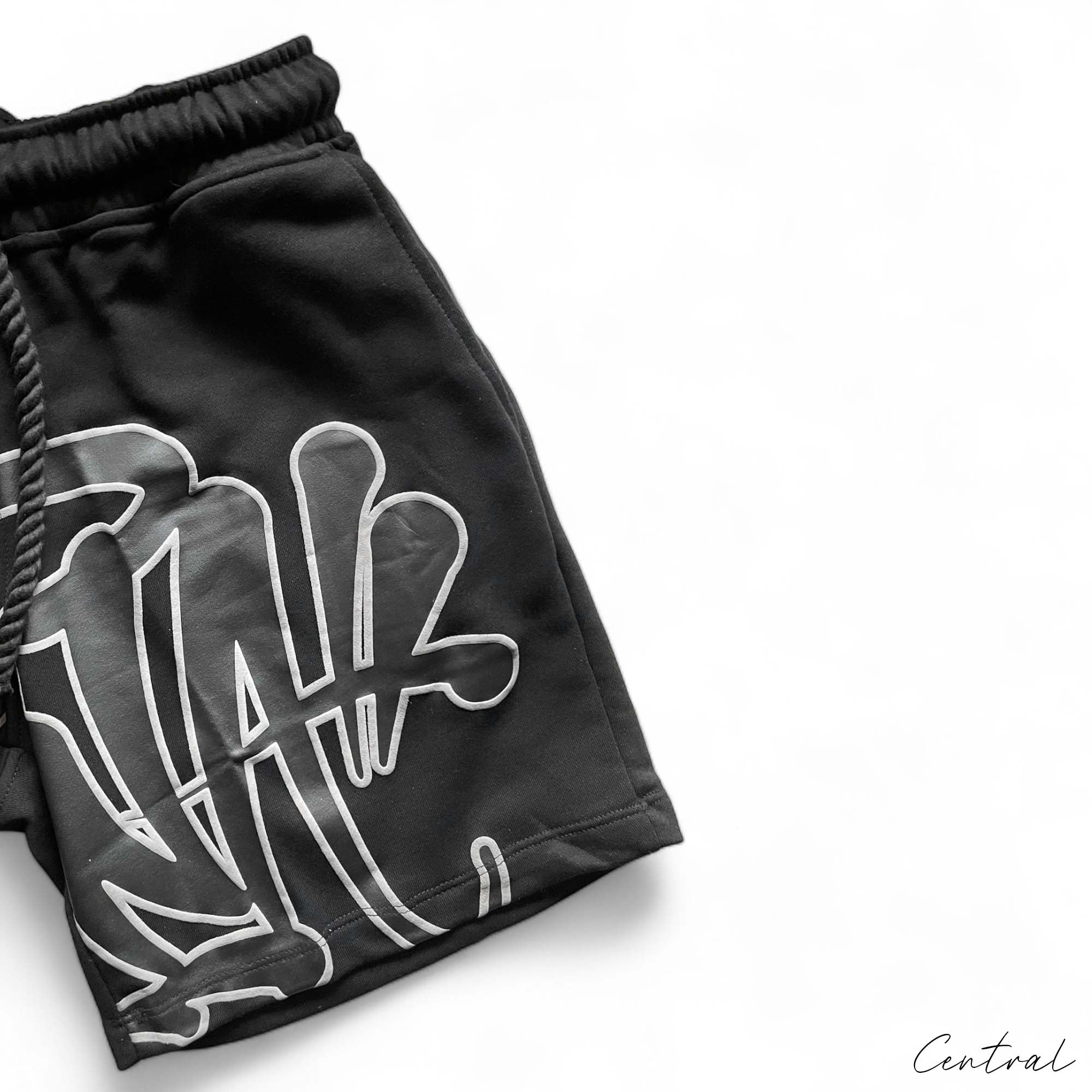Central ae Syna World short set in black featuring a matching t-shirt and shorts, displayed on a neutral background.