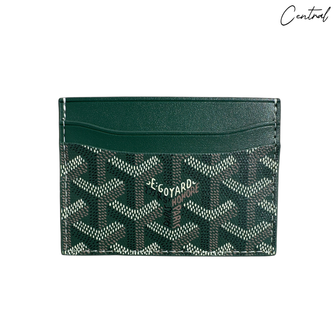 Green Goyard card holder wallet by Central ae, featuring a sleek design and iconic pattern, perfect for organizing cards.