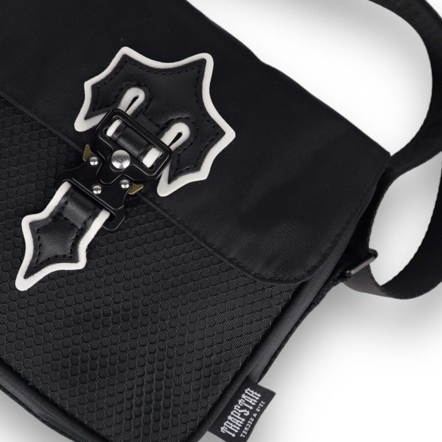 Trapstar black and white Irongate T cross-body bag with adjustable strap and sleek design on a neutral background.
