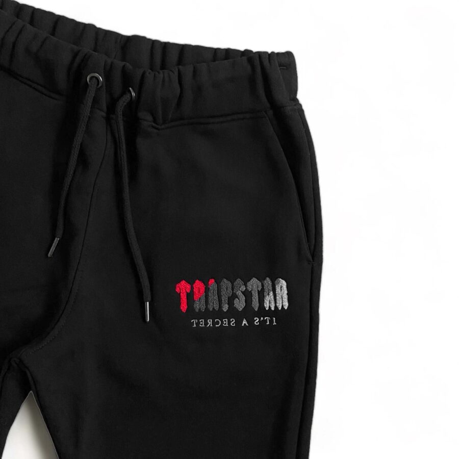 Black and red Trapstar Chenille Decoded tracksuit featuring a hoodie and pants set displayed on a neutral background.