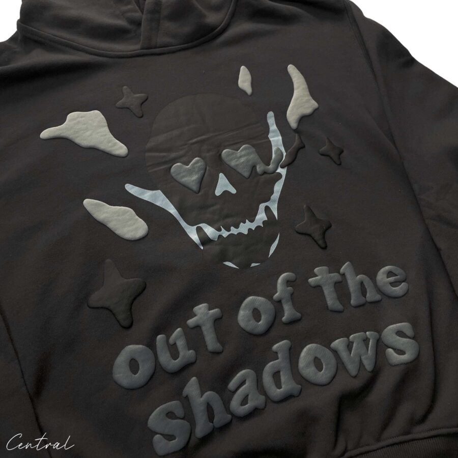 Central ae Broken Planet Out of the Shadows Hoodie in dark fabric with graphic design and adjustable drawstring hood.