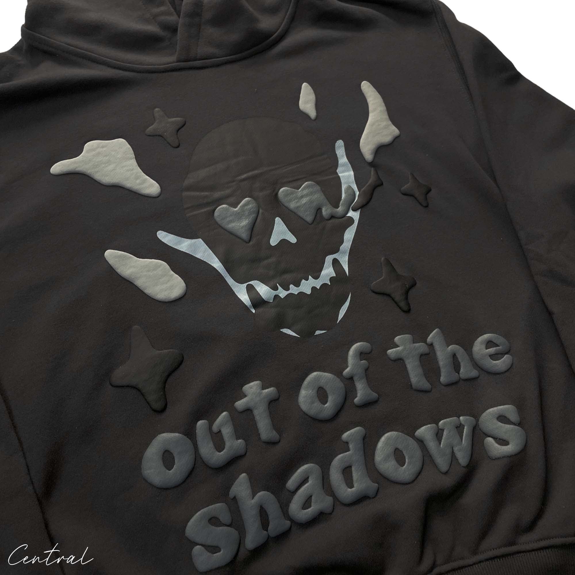 Central ae Broken Planet Out of the Shadows Hoodie in dark fabric with graphic design and adjustable drawstring hood.