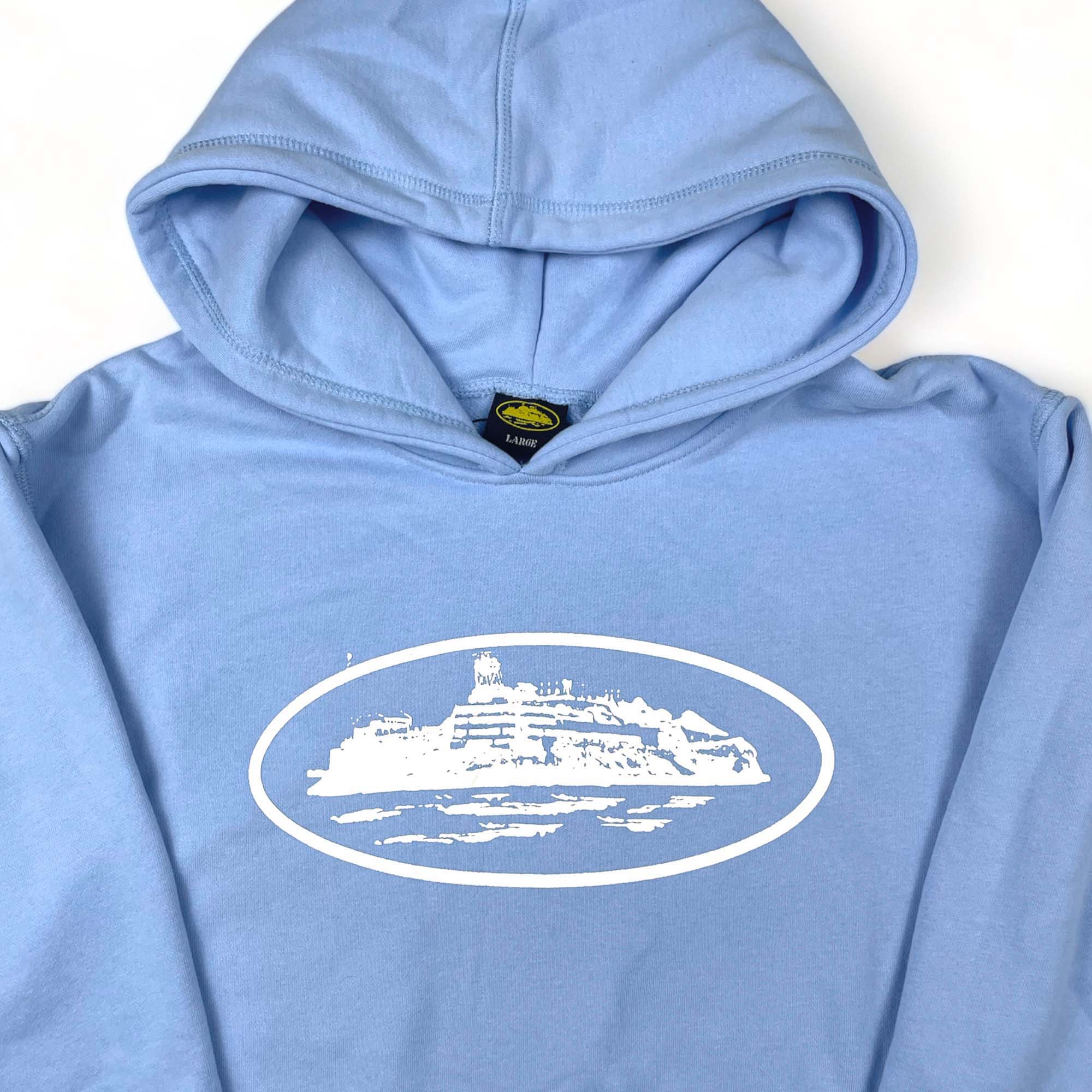 Corteiz Alcatraz hoodie in baby blue featuring a relaxed fit and logo design, perfect for casual wear.