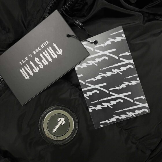 Trapstar Irongate black detachable hooded puffer jacket with a sleek design and quilted texture, displayed on a hanger.