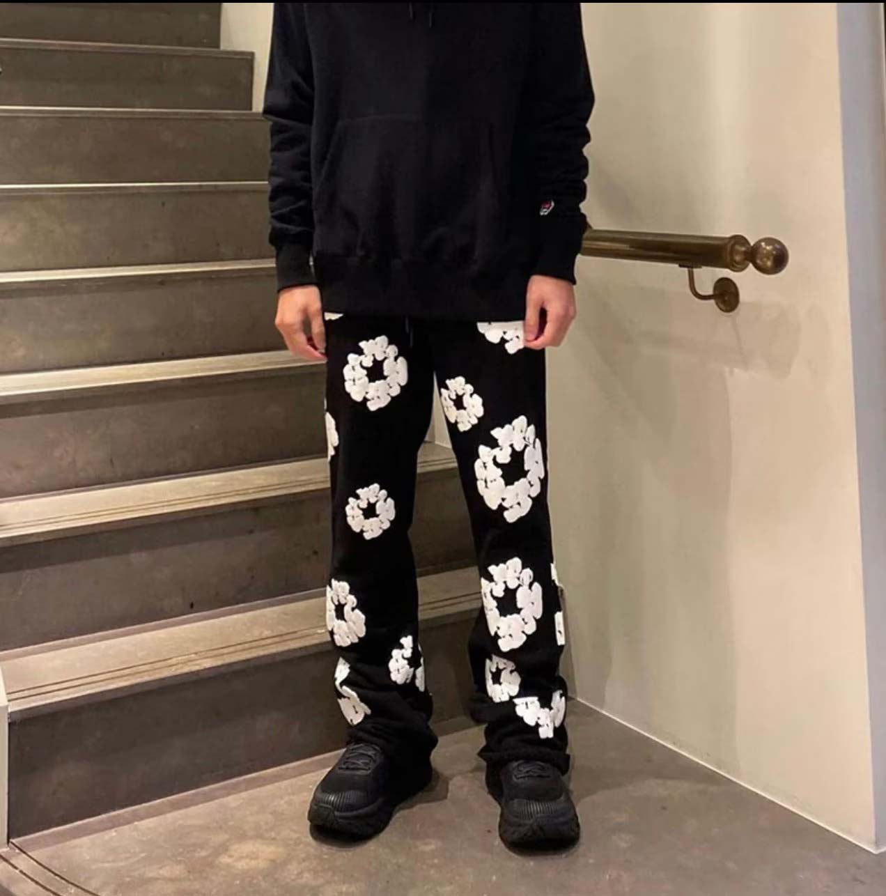 Black sweatpants by Central AE featuring a unique cotton wreath design for a stylish and comfortable fit.