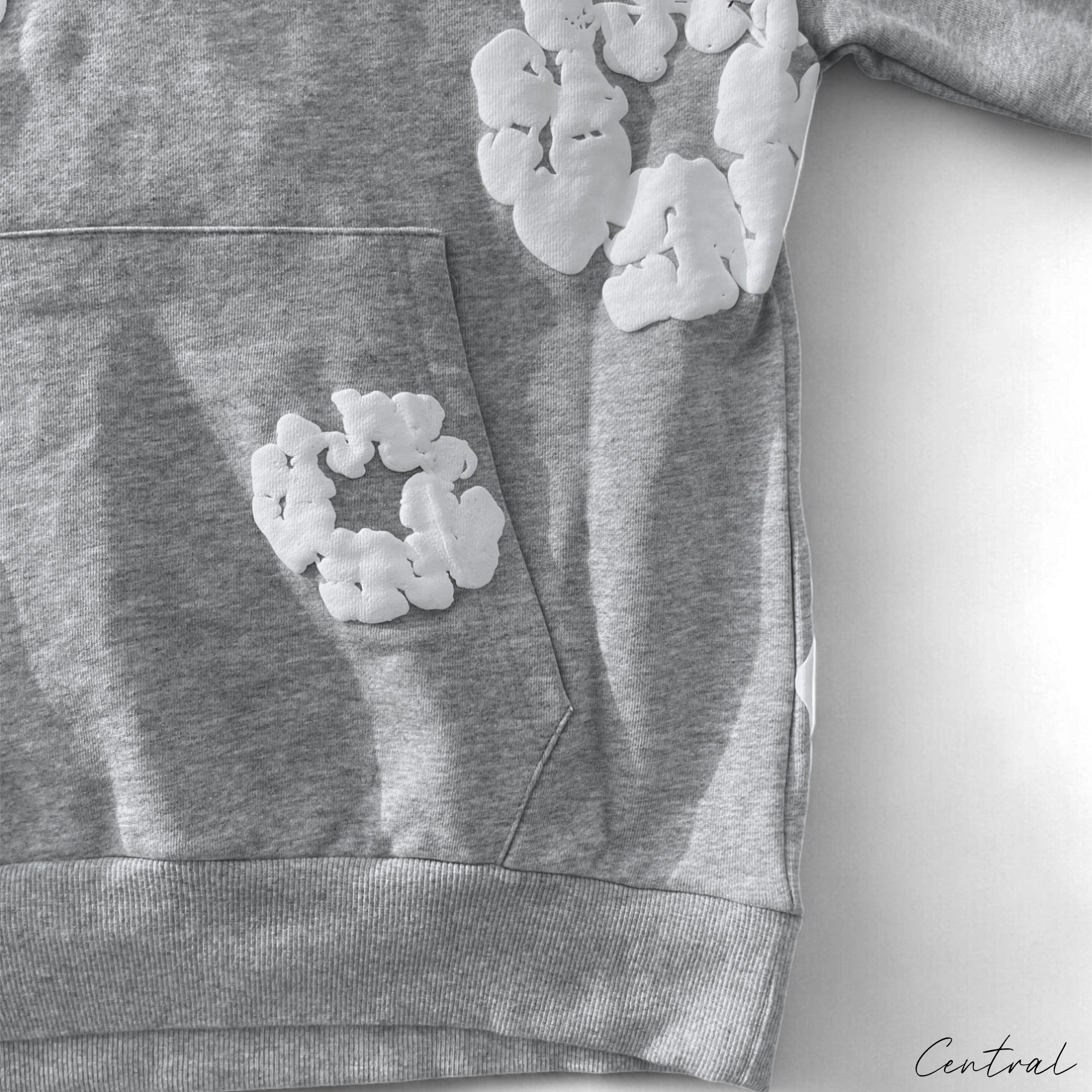 Gray Central ae hoodie featuring a cotton wreath design on the front, displayed on a neutral background.