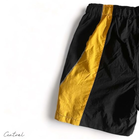 Black and yellow Corteiz spring shorts by Central ae, featuring a comfortable fit and stylish design.