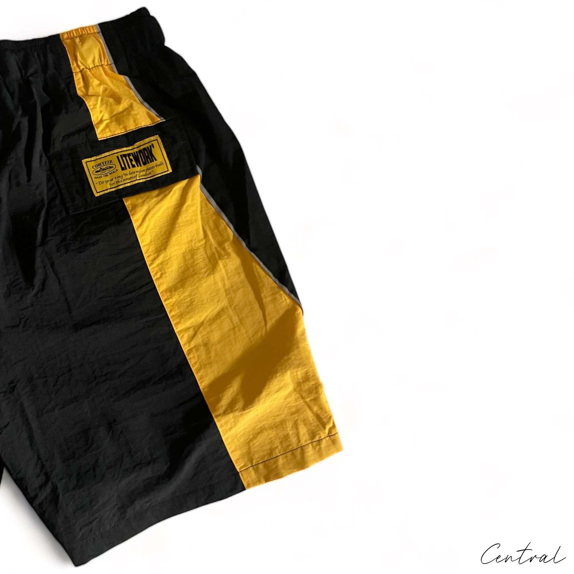 Corteiz black-yellow spring shorts by Central ae, featuring a relaxed fit and stylish design for casual wear.