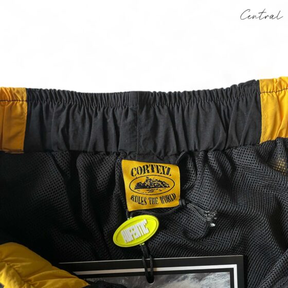Black and yellow Corteiz Spring shorts by Central ae, featuring a comfortable fit and stylish design.