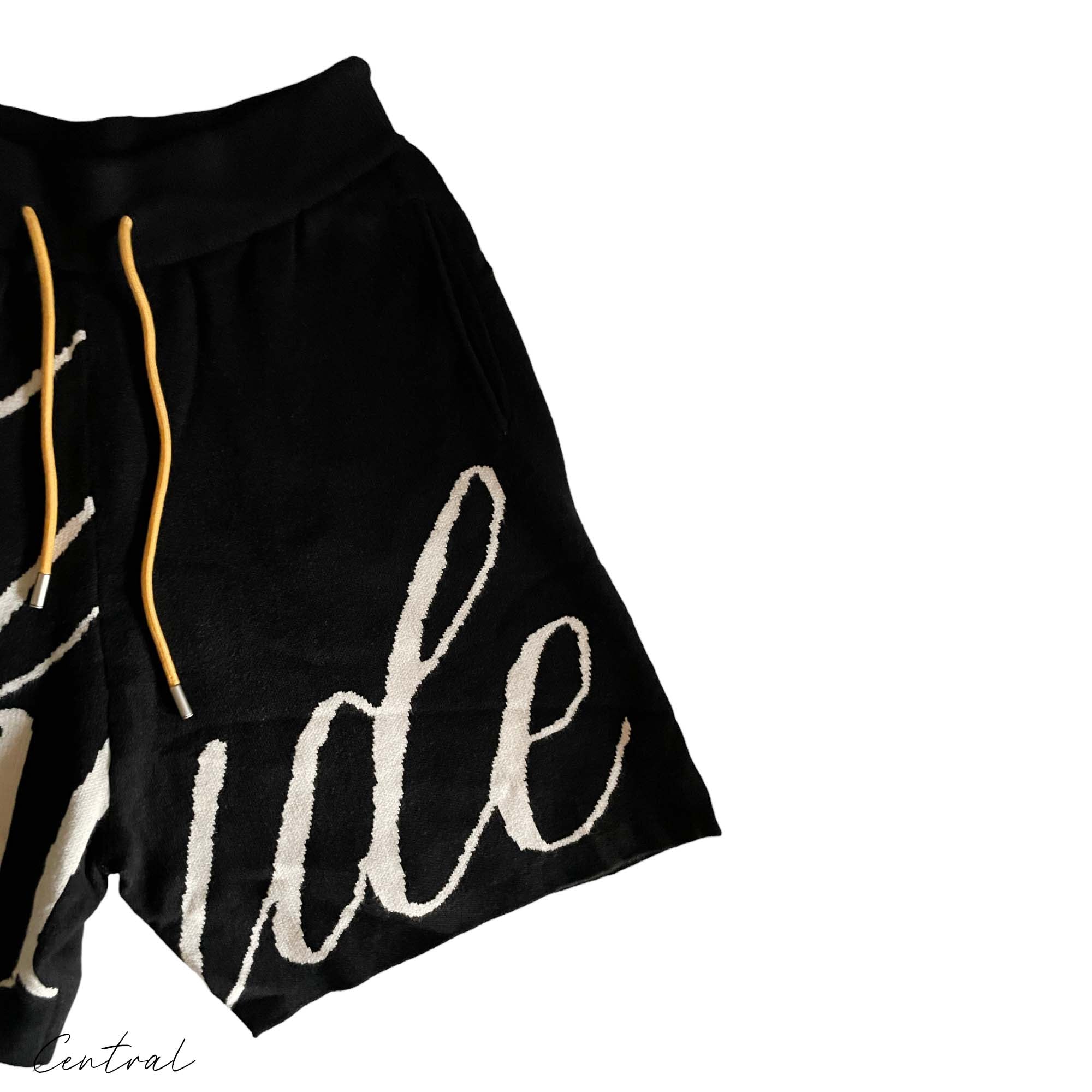 Black and creme Rhude knit logo shorts featuring an elastic waistband and relaxed fit, ideal for casual wear.