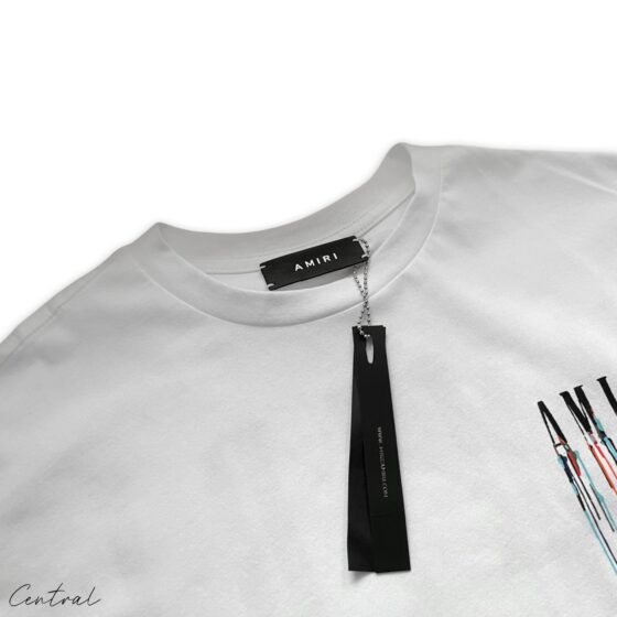 Amiri Paint Drip White T-Shirt by Central ae featuring a unique paint drip design on a classic white tee.