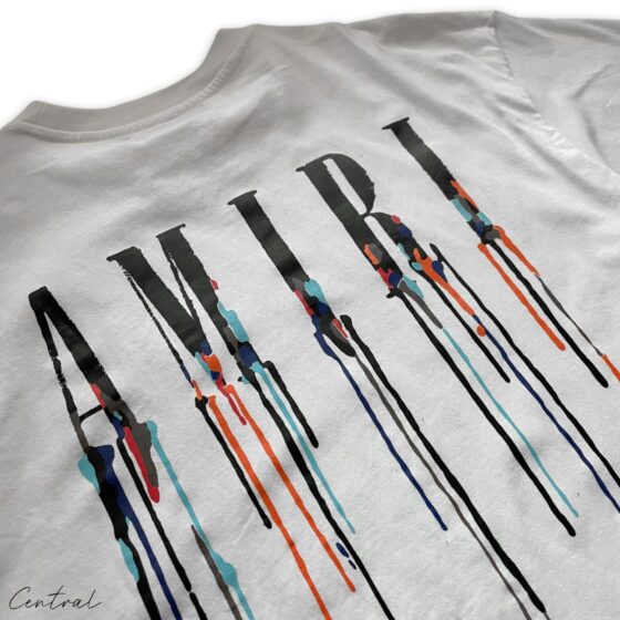White Amiri Paint Drip T-Shirt by Central ae featuring a unique paint drip design on a classic crew neck style.
