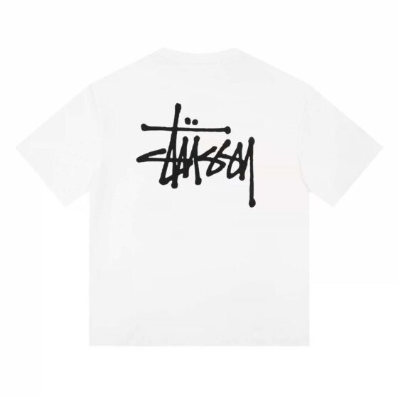 White BASIC STÜSSY TEE t-shirt displayed on a flat surface, showcasing the brand logo and soft cotton fabric.