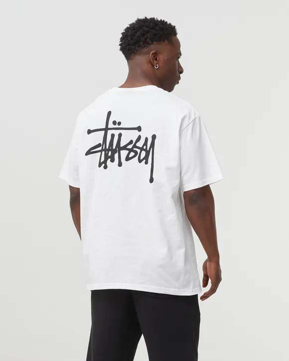 White BASIC STÜSSY TEE t-shirt laid flat, showcasing the iconic logo and soft fabric texture.