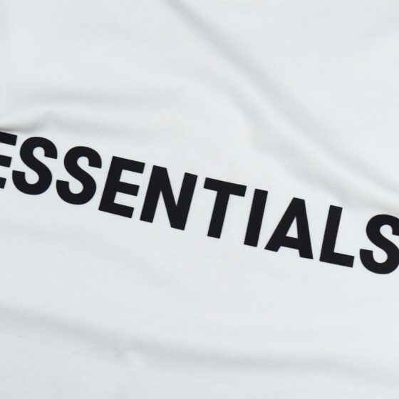 White oversized FOG ESSENTIALS T-shirt displayed flat, showcasing the brand logo and relaxed fit design.