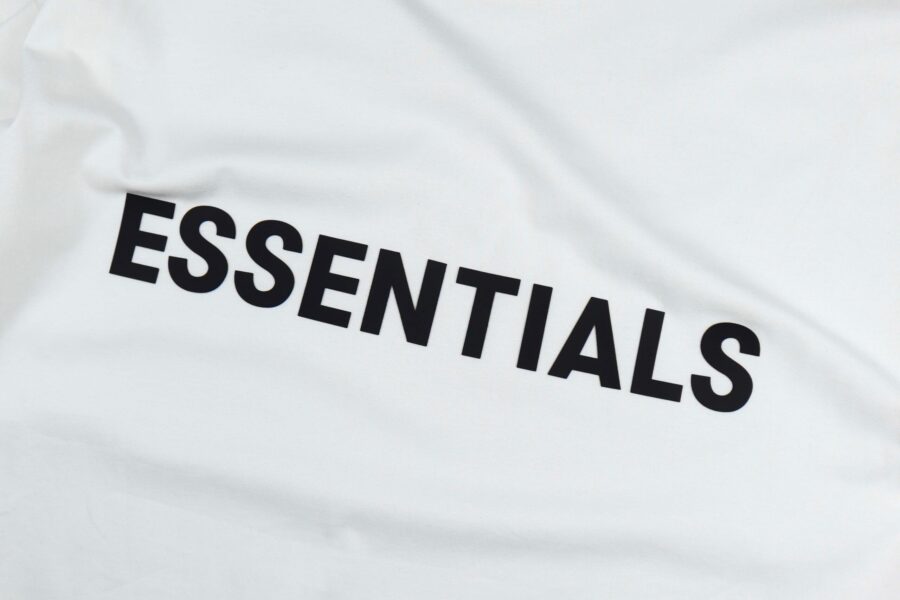 White oversized FOG ESSENTIALS T-shirt displayed flat, showcasing the brand logo and relaxed fit design.