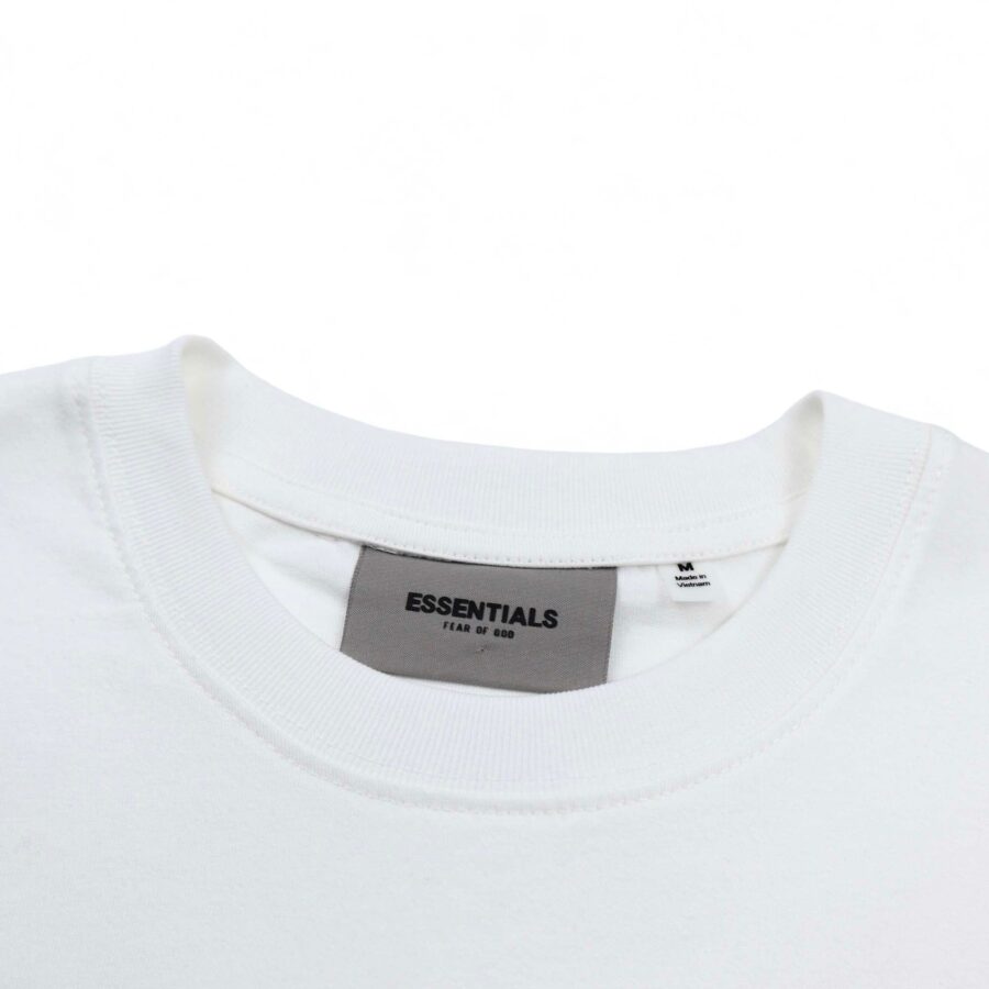 White oversized FOG ESSENTIALS T-shirt displayed on a flat surface, showcasing its relaxed fit and minimalist design.