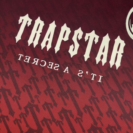 Red gradient Trapstar monogram jersey t-shirt featuring a stylish design and logo detail.