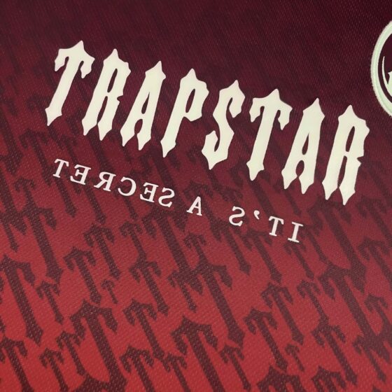 Red gradient Trapstar monogram jersey t-shirt featuring a stylish design and logo detail.