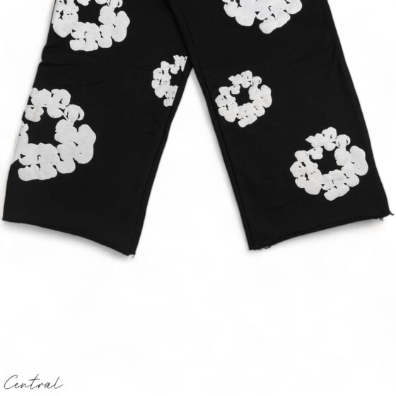 Black READYMADE x DENIM TEARS sweatpants with a relaxed fit and unique detailing, showcased on a flat surface.