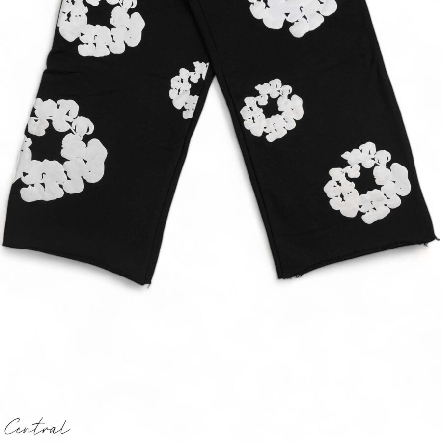 Black READYMADE x DENIM TEARS sweatpants with a relaxed fit and unique detailing, showcased on a flat surface.