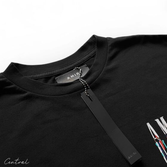 Amiri black t-shirt featuring a paint drip design, showcasing a casual streetwear style.
