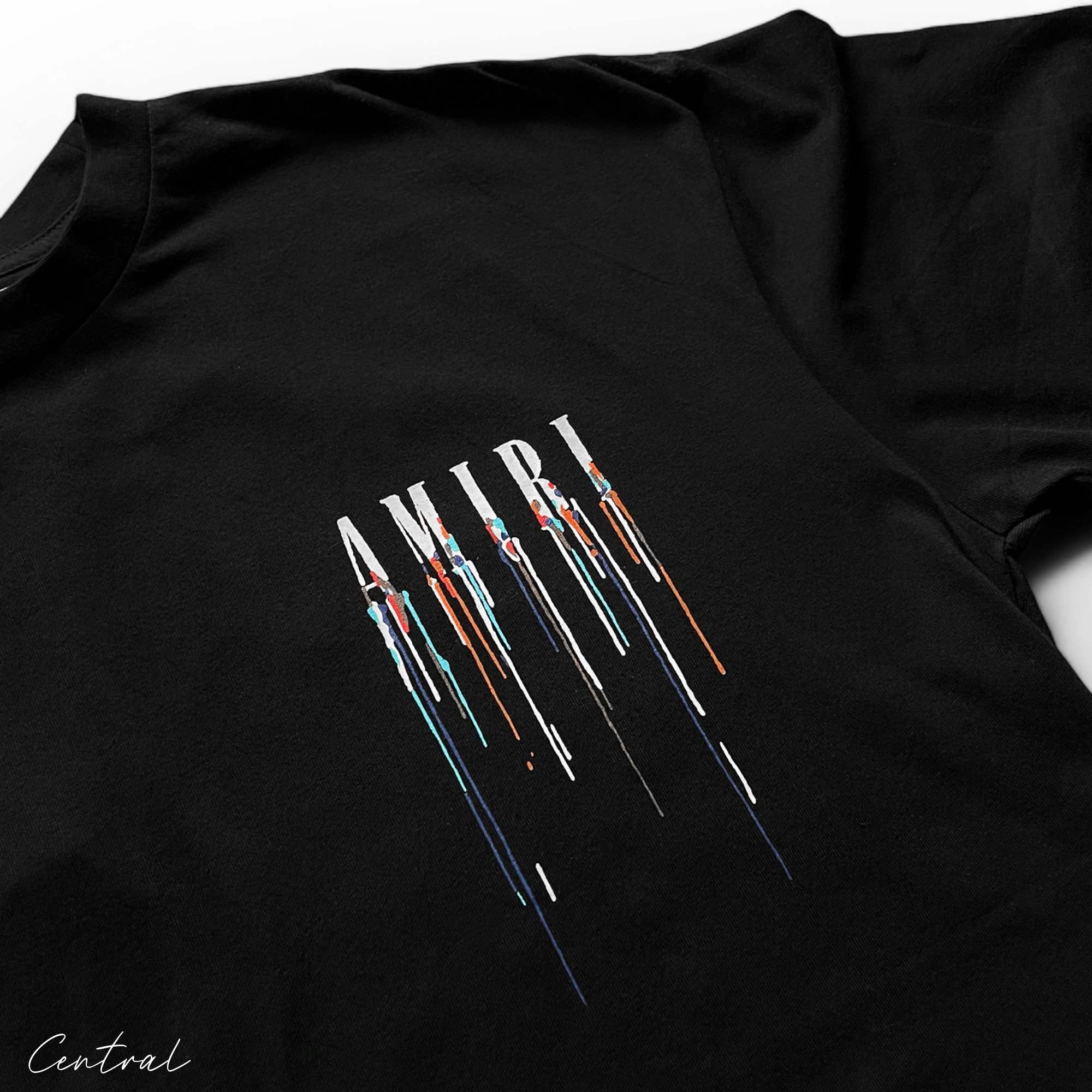 Amiri black t-shirt featuring a paint drip design, showcasing a stylish and modern casual look.